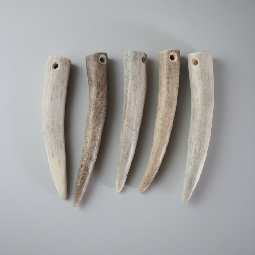 5 deer antler tip beads on a gray background