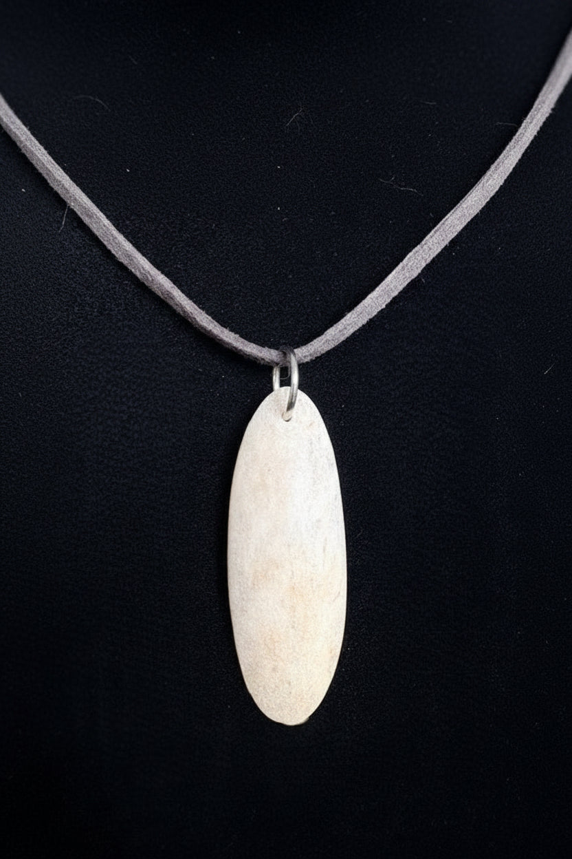 Back view of the Necklace with a deer antler slice pendant on a black background