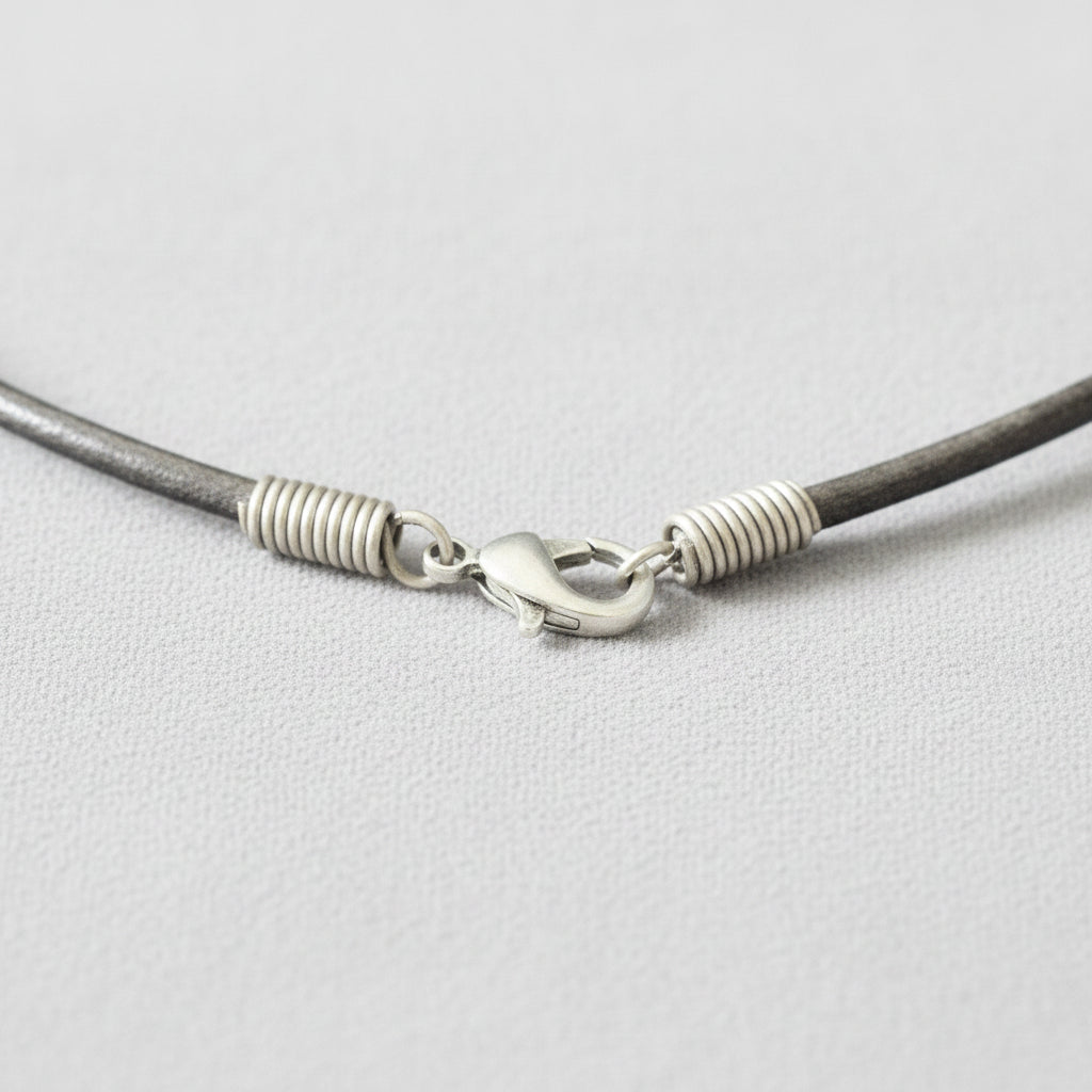 Close-up of a gray cord with a silver clasp on a gray background
