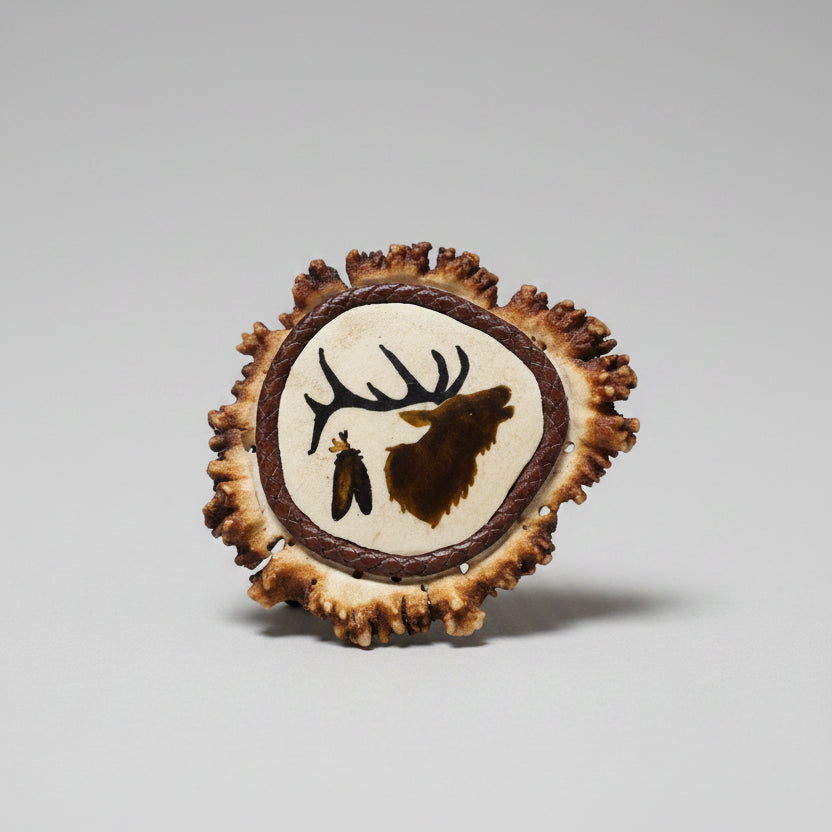 two feathers and a elk head profile inlaid on a elk cornet on a gray background
