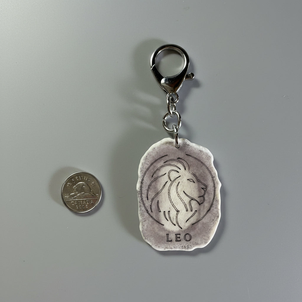 Other side of moose antler zodiac sign keychain on a gray backgroud