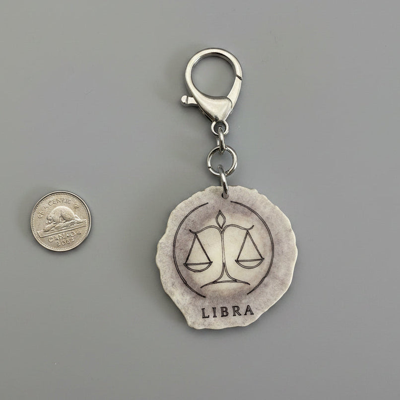 Other side of moose antler zodiac sign keychain on a gray background