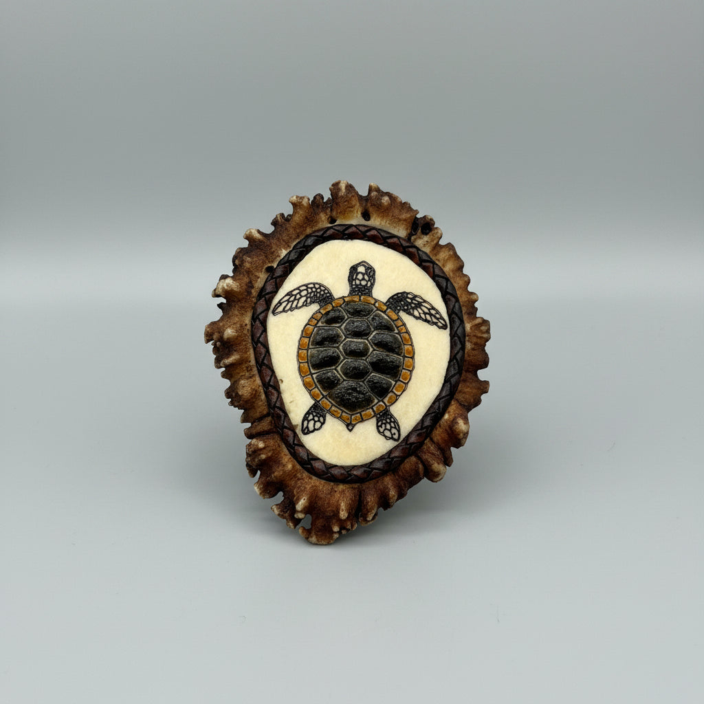 Decorative elk antler cornet with a spirit turtle engraved and inlayed on a gray background
