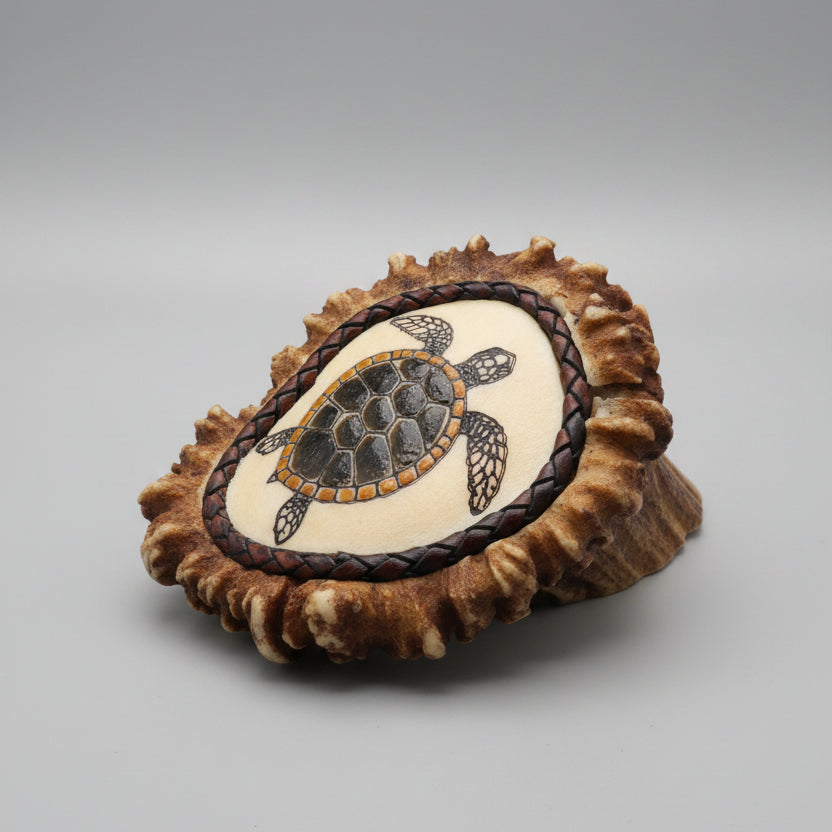 side view Decorative elk antler cornet with a spirit turtle engraved and inlayed on a gray background