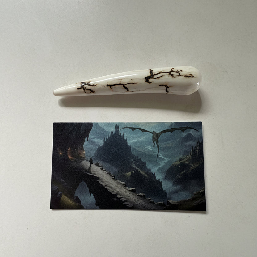 Dragon tooth like made of a deer antler tip with black strike on a gray background