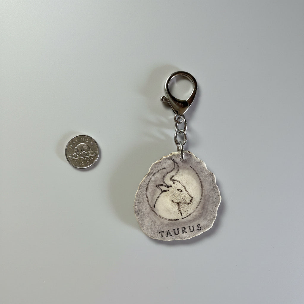 Moose antler zodiac sign keychain on a gray background