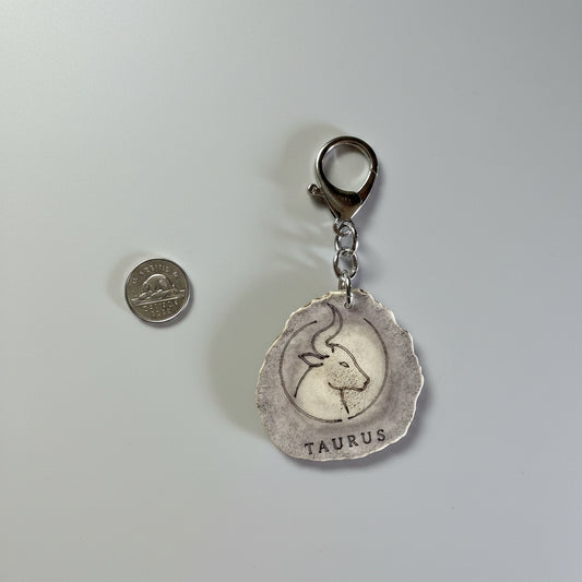 Moose antler zodiac sign keychain on a gray background