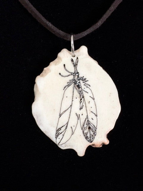 Necklace with a pendant featuring feather design on a black background