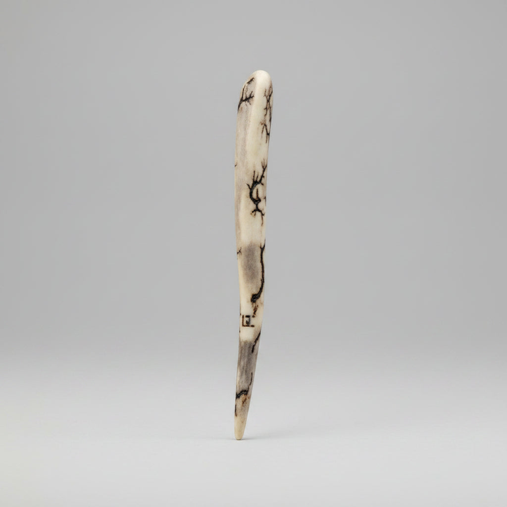 bottom view of the Natural deer antler comfort tine polished and decorated with strikes on a gray background