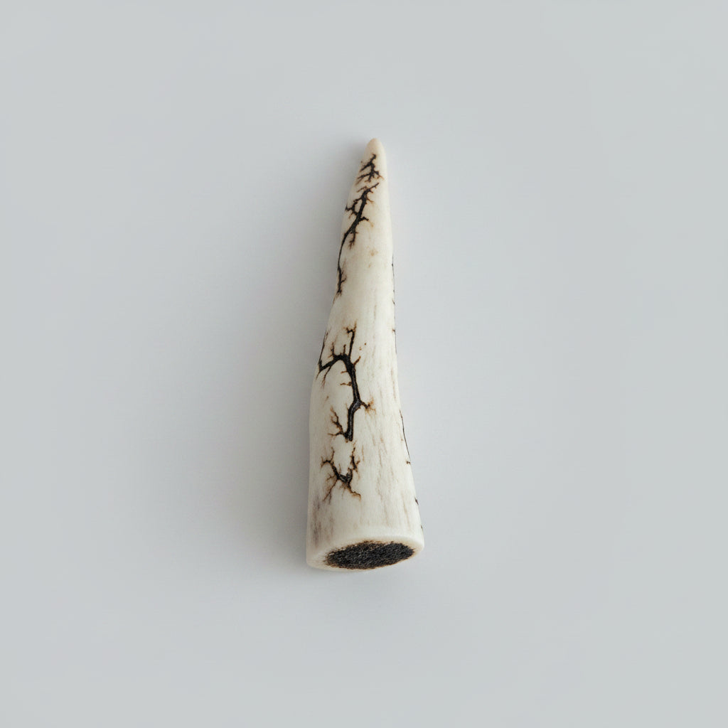 Front view of the Natural deer antler comfort tine polished and decorated with strikes on a gray background