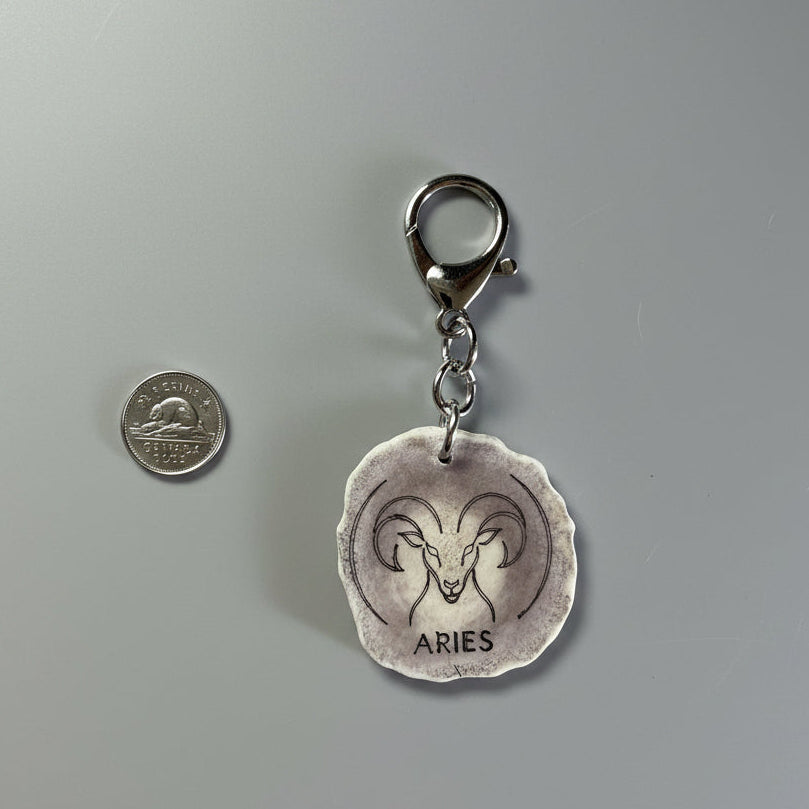 other side of a moose antler zodiac sign keychain on a gray background
