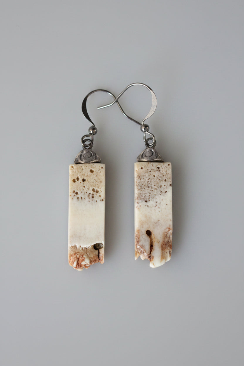 Pair of earrings with rectangular, textured antler on a black background