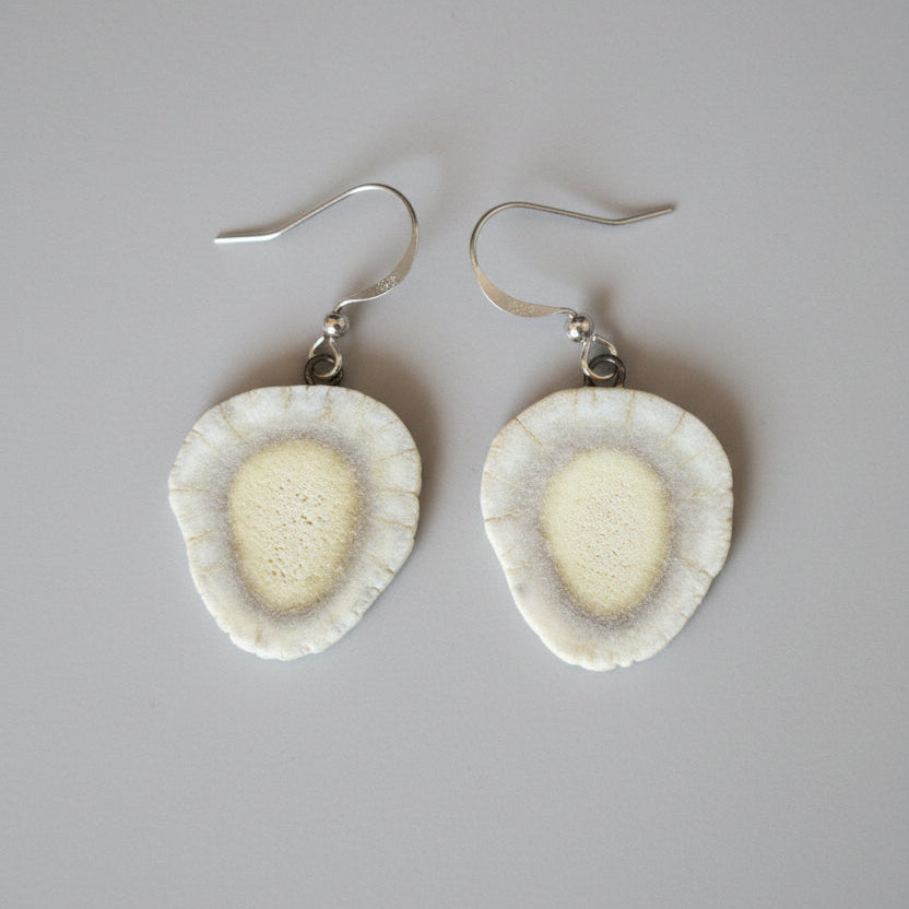 Natural deer antler earrings on a gray background