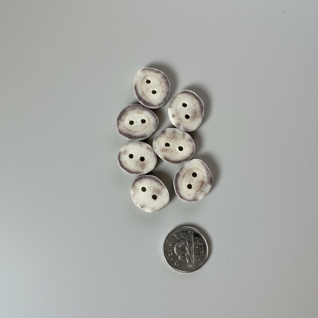Deer antler button on a gray background