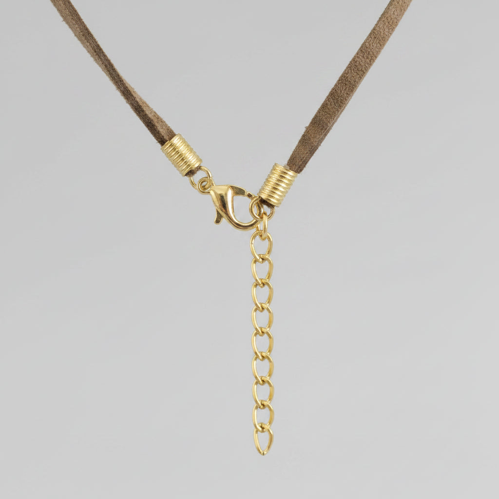 Close-up of a necklace with a gold chain extension on a dark background