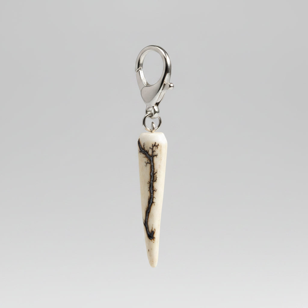 Deer antler tip keychain with silver clasp on a gray background