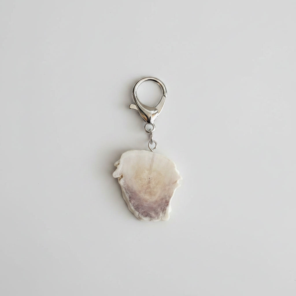 Bottom view of a Silver keychain with goat engraved on piece of deer antler on a gray background