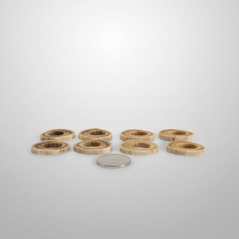 Side view of 8 deer antler slice, with a hole on the middle on a gray background