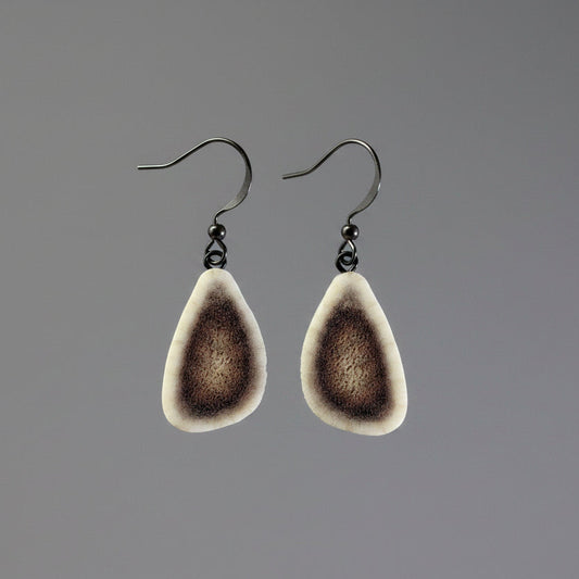 Deer antler earring on a gray background
