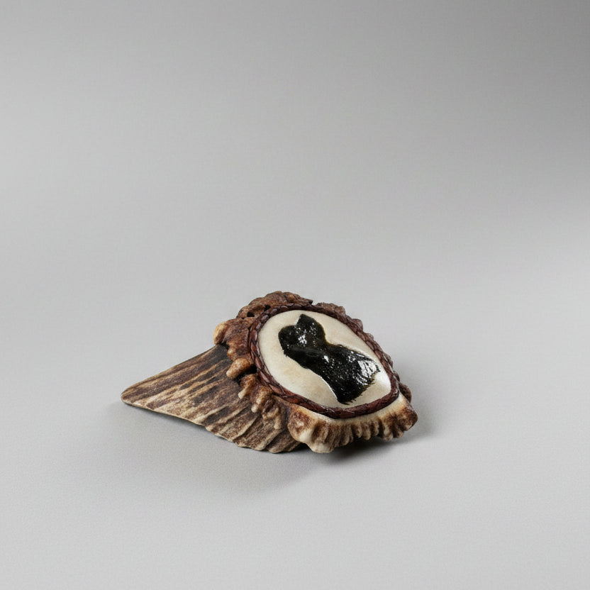 other side of the carved dog on an elk antler cornet on a gray background