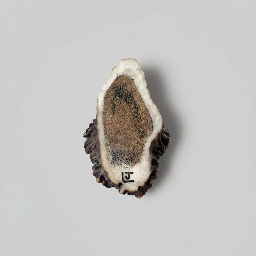 Bottom of the wolf head with the signature of the artist on a gray background