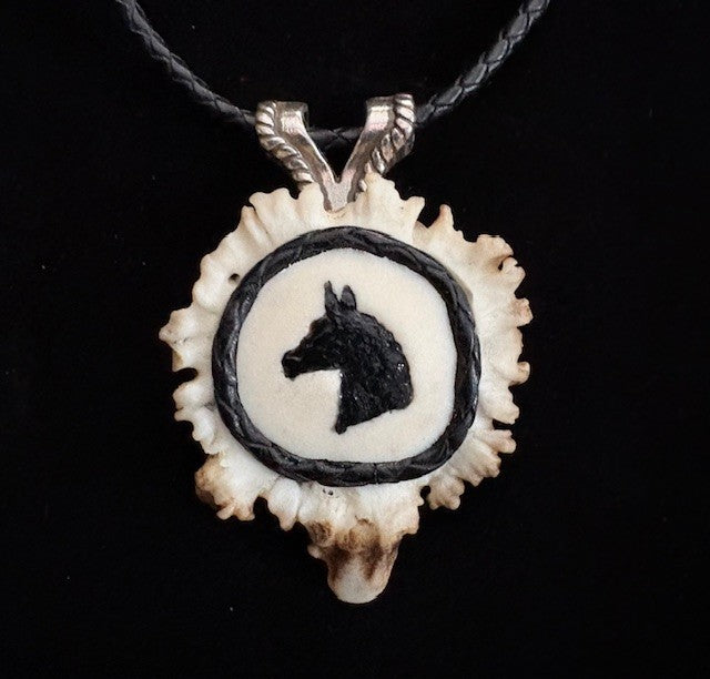 Pendant with horse silhouette on a black background