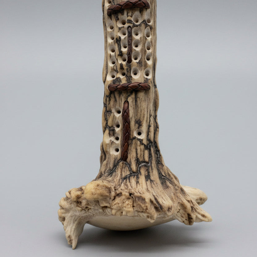 Closed up of the end of the elk antler cribbage board on a gray background