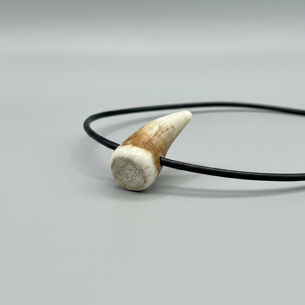 Top view of the elk antler tip necklace with aroma diffuser on a gray background 