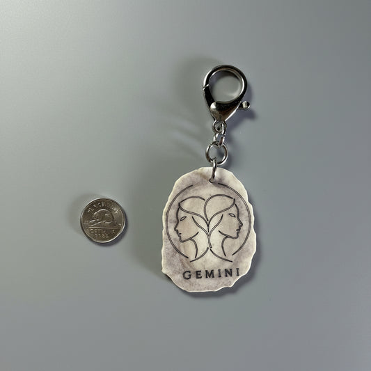 Moose antler zodiac sign keychain on a gray background