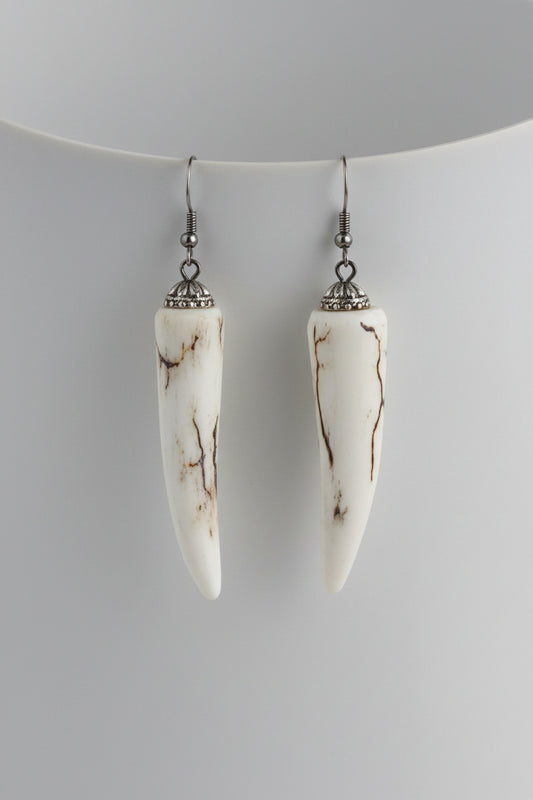 Pair of deer antler tip earrings on a gray background