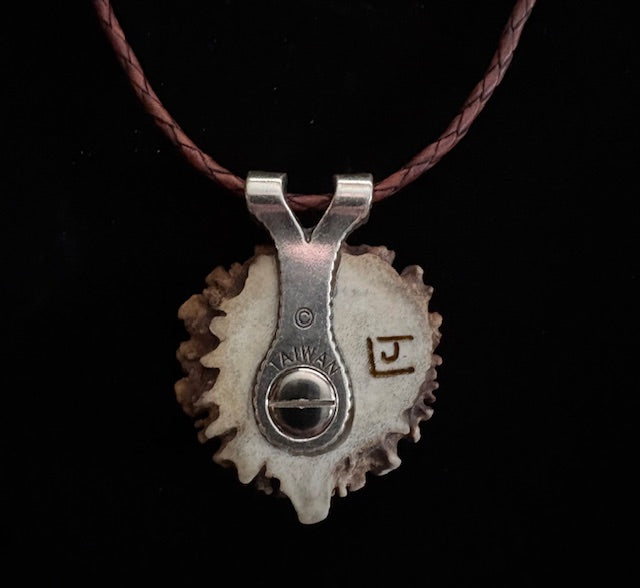 Back view of Necklace with a pendant with bear in laid design on a dark background