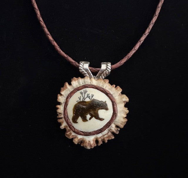 Necklace with a pendant with bear in laid design on a dark background