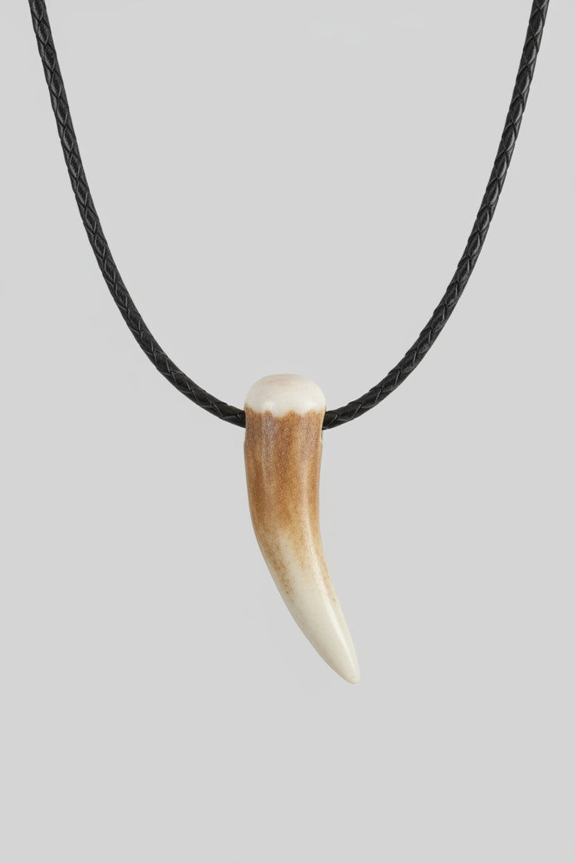 other side of the Deer antler tip pendant on a black leather cord on a gray background