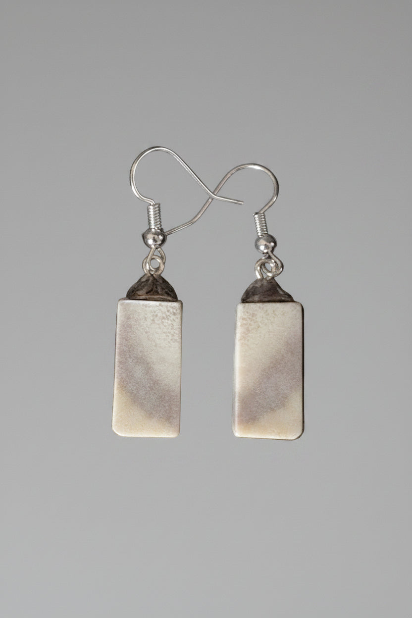 Pair of moose antler earrings on a gray background