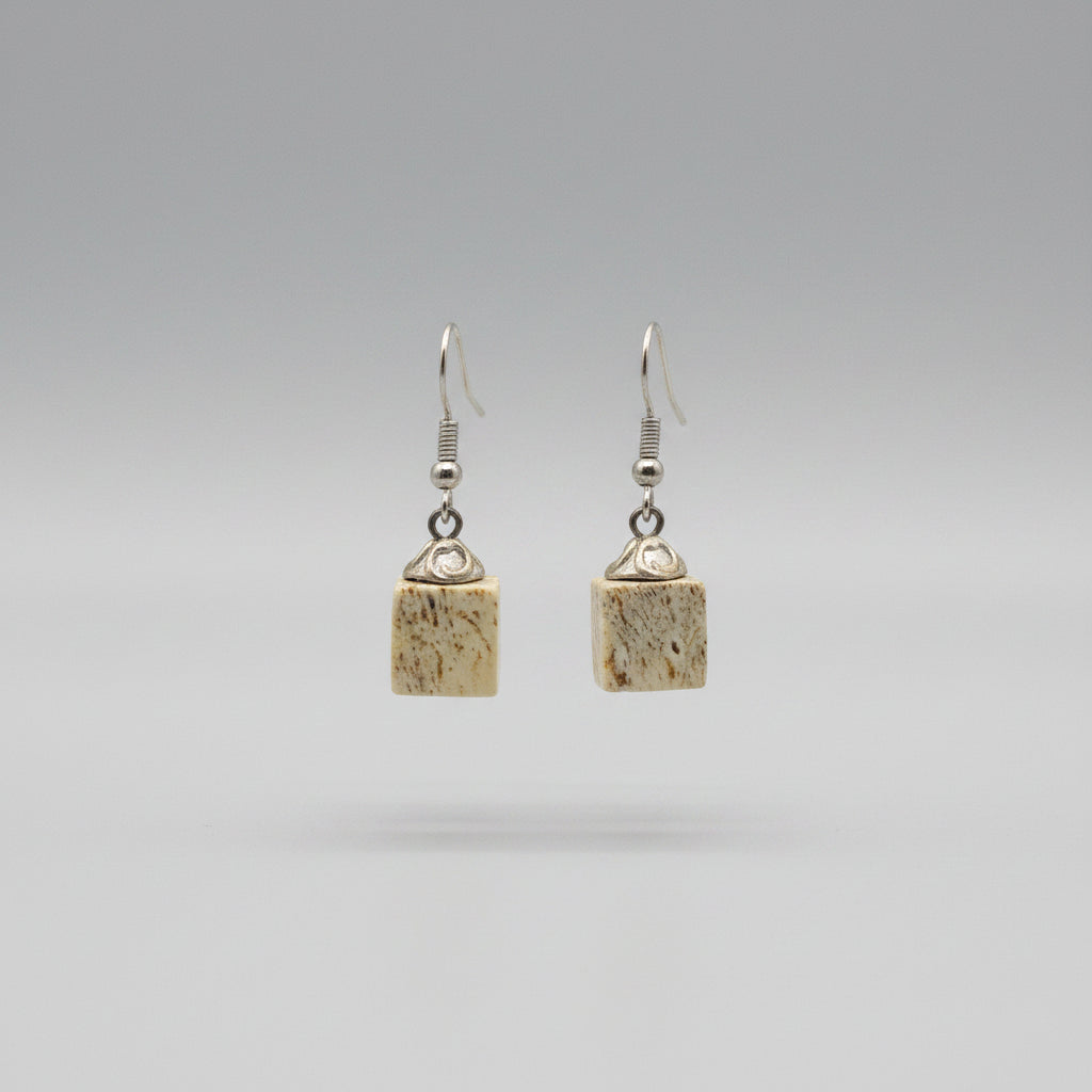 Pair of earrings with square-shaped beads elk antler on a gray background