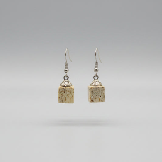 Pair of earrings with square-shaped beads elk antler on a gray background