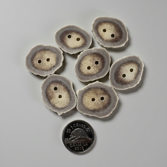 7 Deer antler buttons on a gray background