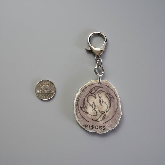 Moose antler zodiac sign keychain on a gray background