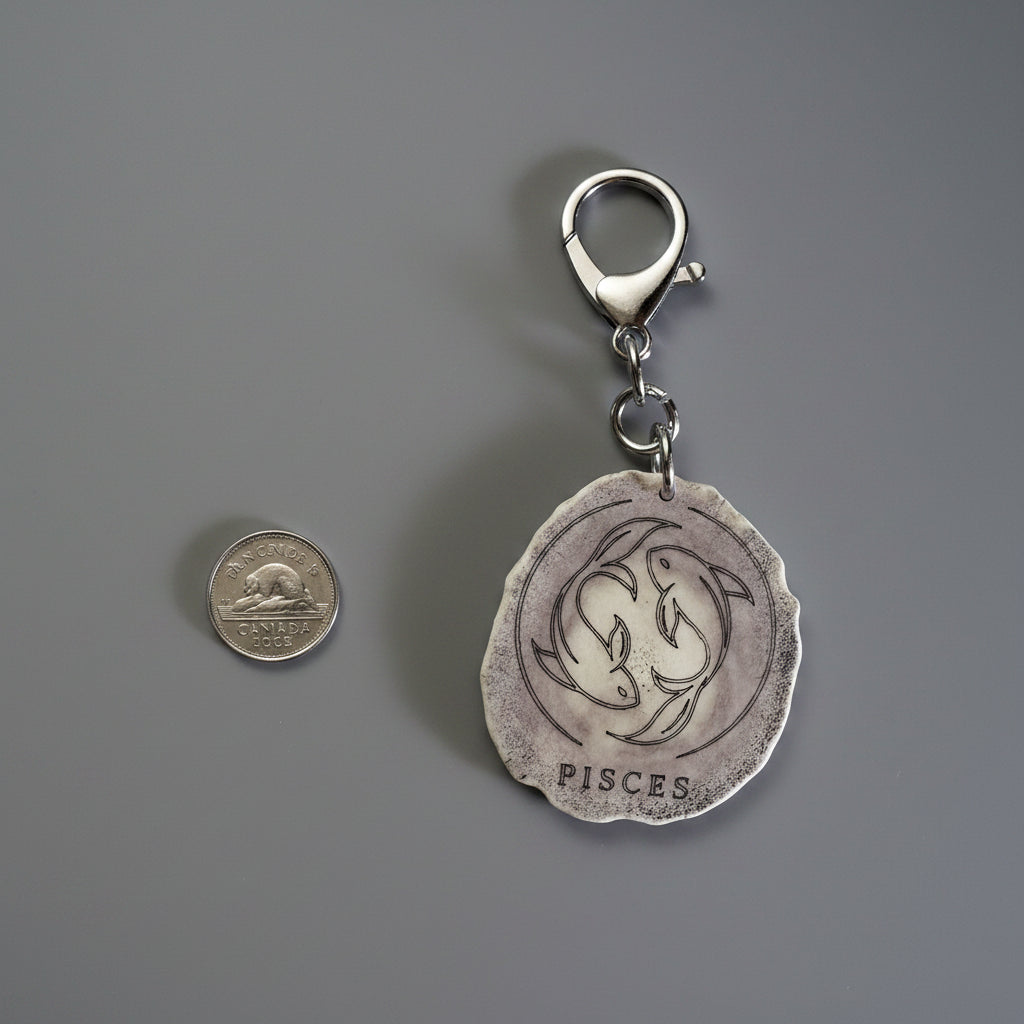 Other side of moose antler zodiac sign keychain on a gray background