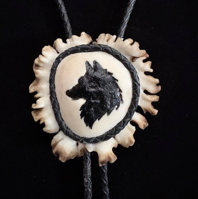 Bolo tie with wolf design on a black background