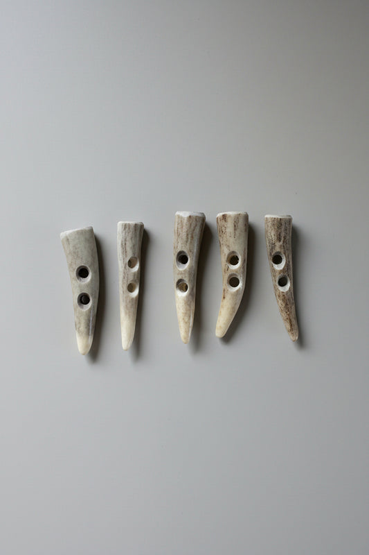 5 Deer antler toggle buttons on a gray background