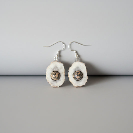 Deer antler earrings with a semi precious gem on a gray background